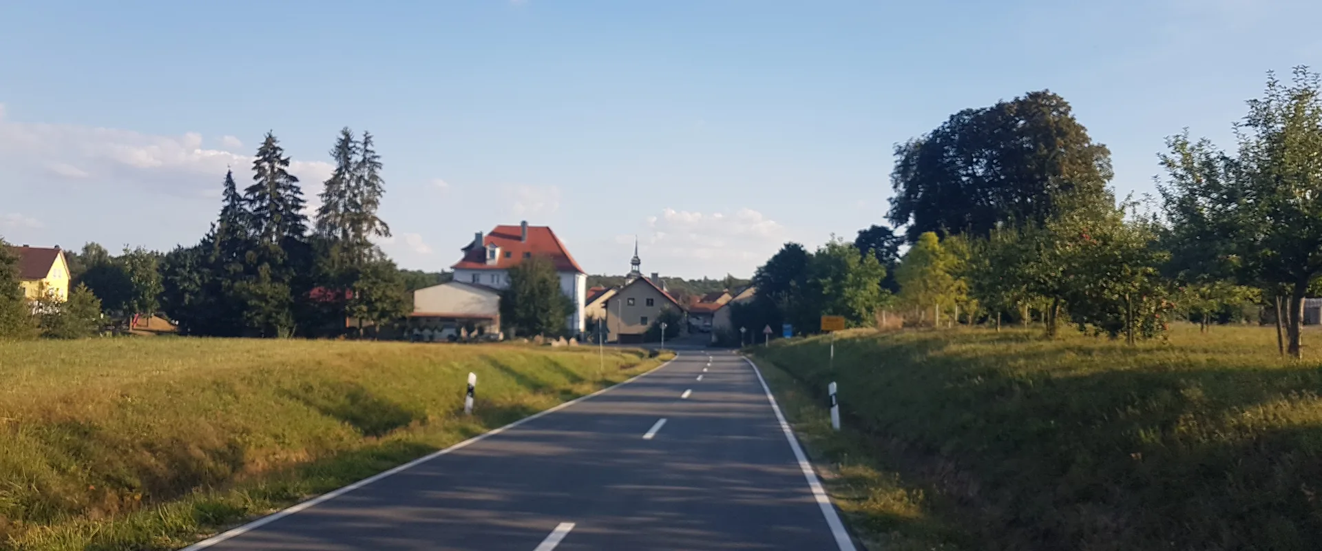 Ortseinfahrt von Buch am Ahorn in der Gemeinde Ahorn im Main-Tauber-Kreis mit Wohnhäusern und Kirchturm